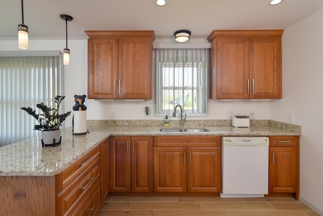 kitchen featuring light stone countertops, dishwasher, pendant lighting, and sink