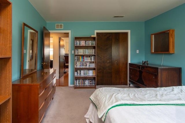 bedroom featuring light colored carpet and a closet