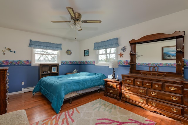 bedroom with hardwood / wood-style flooring, ceiling fan, and baseboard heating