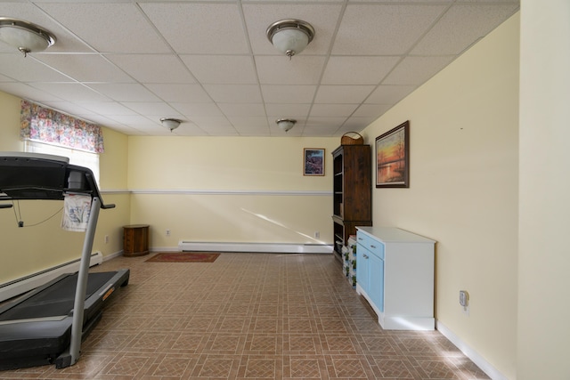 workout room featuring a paneled ceiling and a baseboard radiator