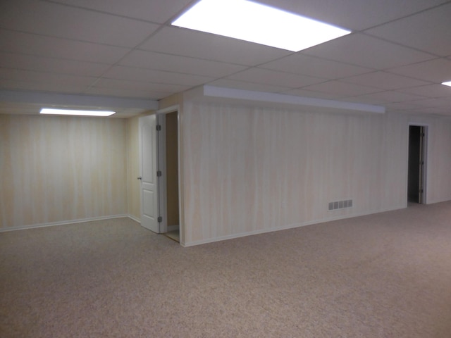 finished basement with a paneled ceiling, carpet, and visible vents