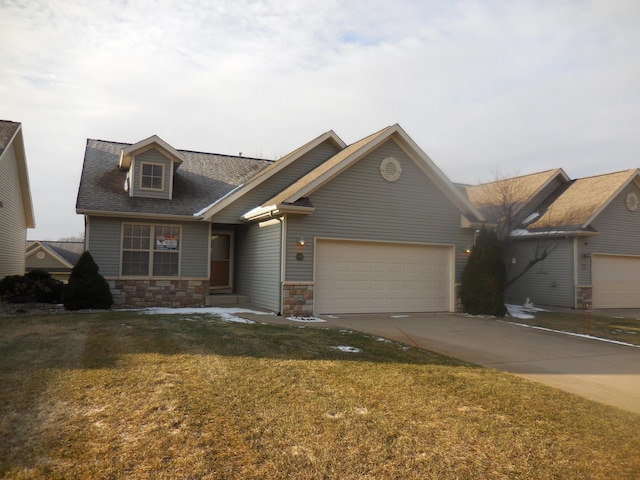 view of front of house featuring concrete driveway, stone siding, an attached garage, and a front yard