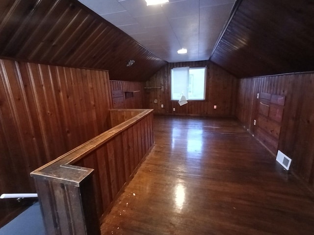 bonus room with dark hardwood / wood-style floors, lofted ceiling, and wooden walls