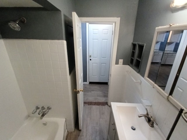 bathroom with bathing tub / shower combination, hardwood / wood-style floors, and vanity