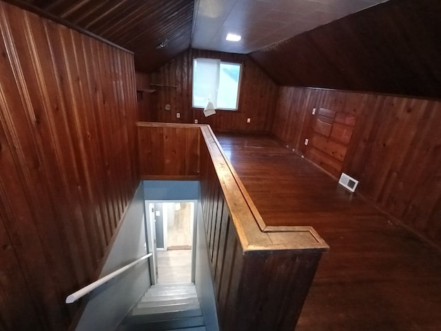 bonus room featuring wood walls, lofted ceiling, and dark wood-type flooring