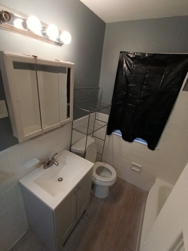 bathroom with hardwood / wood-style flooring, vanity, toilet, and decorative backsplash