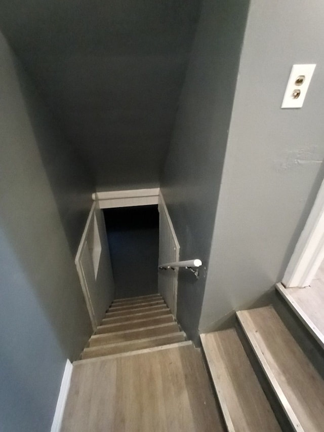 stairs featuring hardwood / wood-style floors