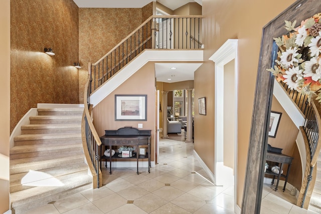 staircase featuring tile patterned floors and a towering ceiling