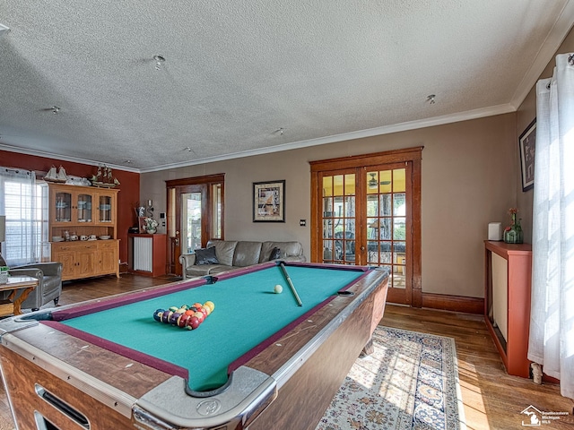 recreation room featuring french doors, crown molding, plenty of natural light, hardwood / wood-style flooring, and pool table