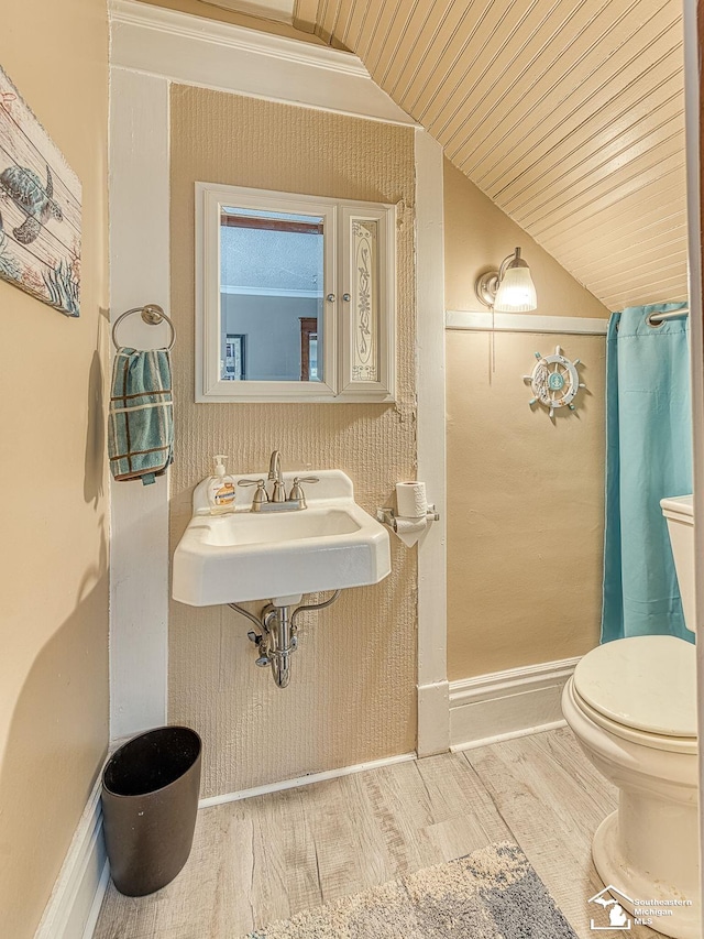 bathroom with sink, vaulted ceiling, hardwood / wood-style flooring, toilet, and wood ceiling