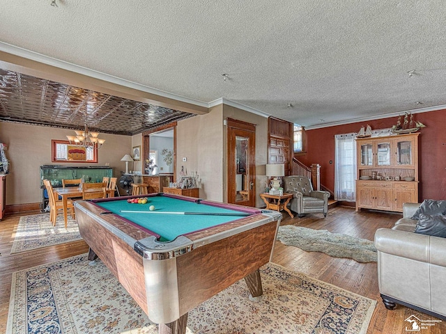 recreation room with crown molding, hardwood / wood-style floors, a chandelier, and billiards