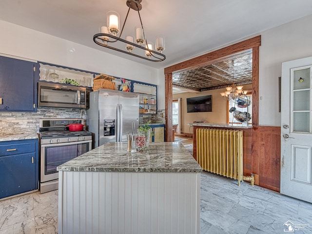 kitchen featuring blue cabinetry, radiator heating unit, stainless steel appliances, tasteful backsplash, and decorative light fixtures