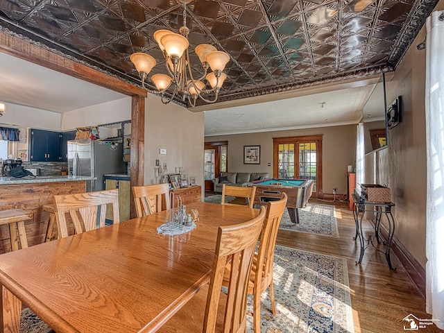 dining area featuring hardwood / wood-style floors, billiards, and a chandelier