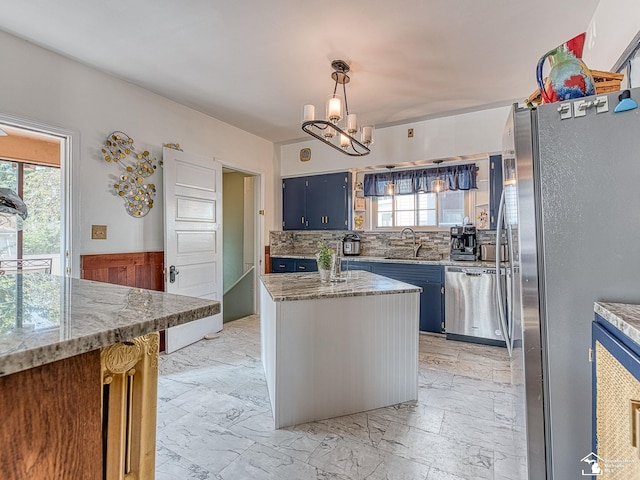 kitchen with a center island, sink, stainless steel appliances, hanging light fixtures, and a chandelier