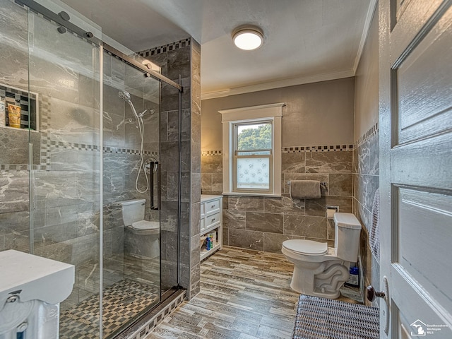 bathroom featuring hardwood / wood-style flooring, toilet, ornamental molding, tile walls, and an enclosed shower