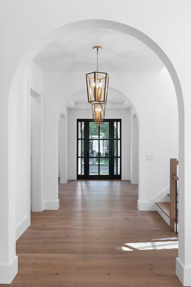 foyer featuring french doors, dark hardwood / wood-style floors, and an inviting chandelier