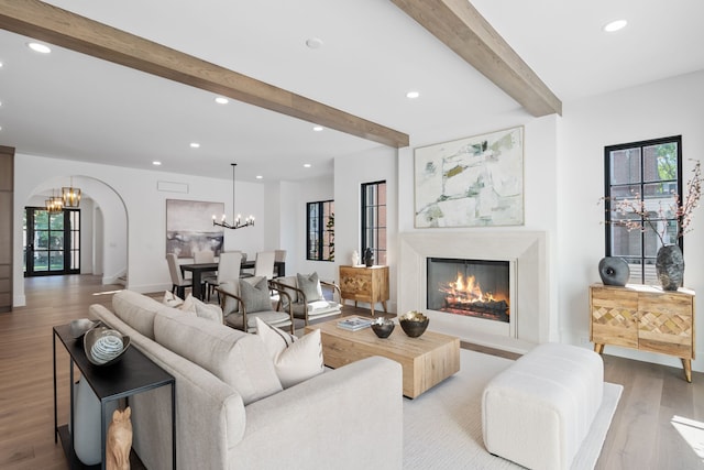 living room featuring beamed ceiling and light wood-type flooring