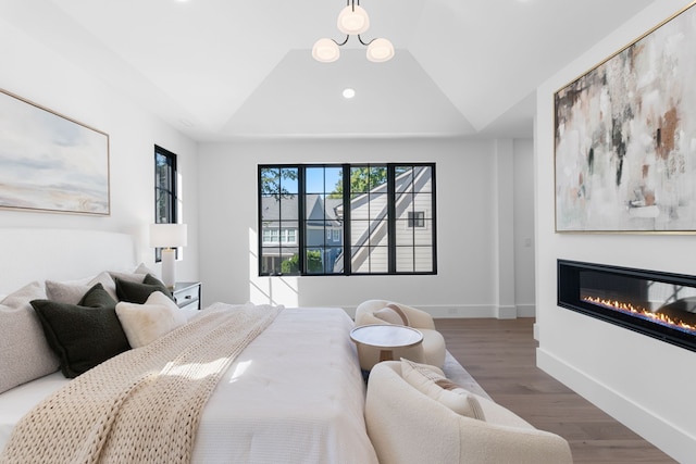 bedroom with dark hardwood / wood-style floors and vaulted ceiling