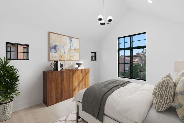 bedroom featuring high vaulted ceiling, light hardwood / wood-style floors, and a notable chandelier