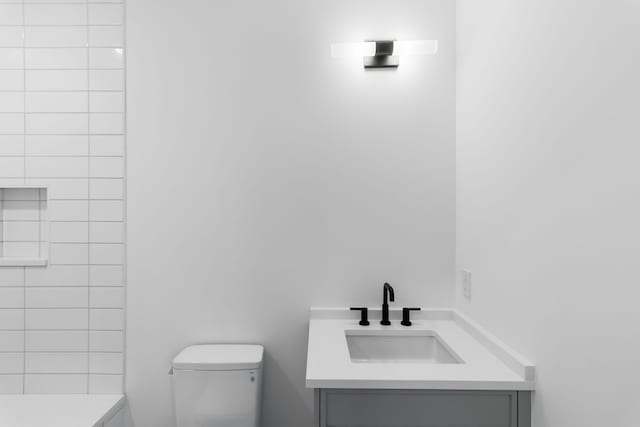 bathroom with a shower, vanity, and toilet