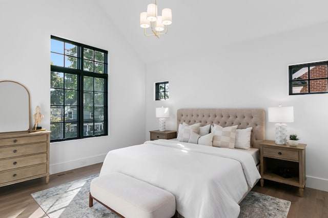 bedroom with dark wood-type flooring, high vaulted ceiling, and a chandelier