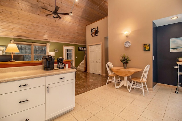 kitchen with high vaulted ceiling, white cabinetry, wooden ceiling, and light tile patterned flooring