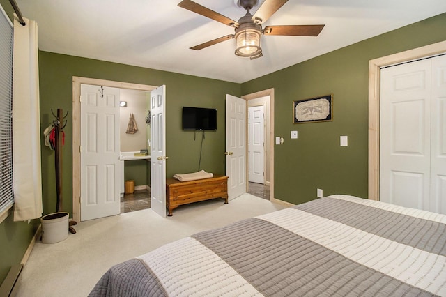 carpeted bedroom with baseboard heating, ceiling fan, and a closet