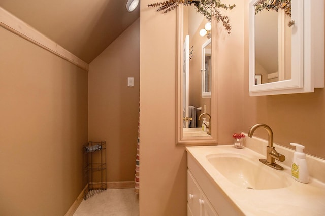 bathroom with tile patterned floors, lofted ceiling, and vanity