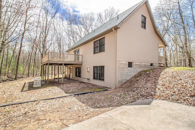 4714 N Lincoln Rd, Ludington, MI 49431 - view of property exterior with a patio area, roof with shingles, and a wooden deck