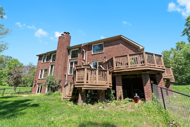 back of property featuring a lawn and a wooden deck