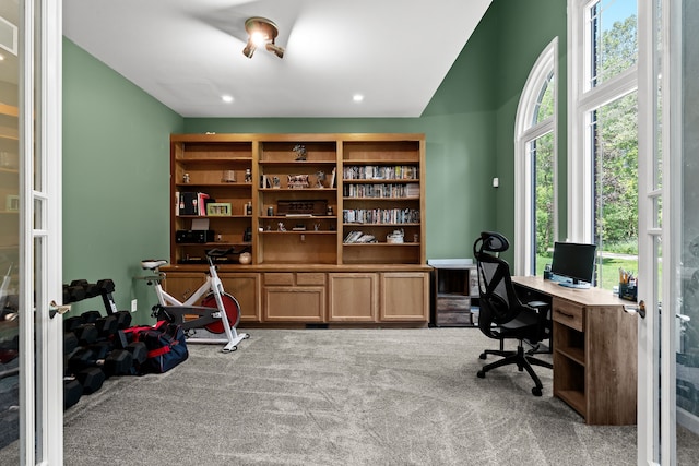 carpeted home office with vaulted ceiling