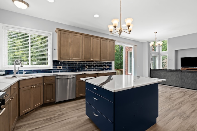 kitchen with dishwasher, a center island, decorative light fixtures, a notable chandelier, and light hardwood / wood-style floors