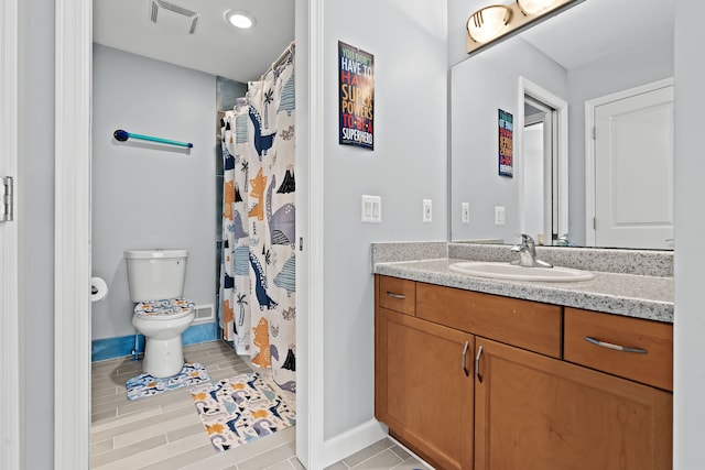 bathroom featuring walk in shower, tile patterned flooring, vanity, and toilet