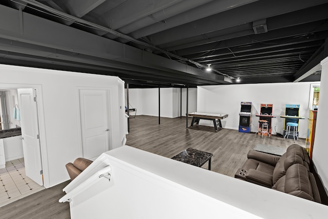 basement featuring hardwood / wood-style flooring and rail lighting