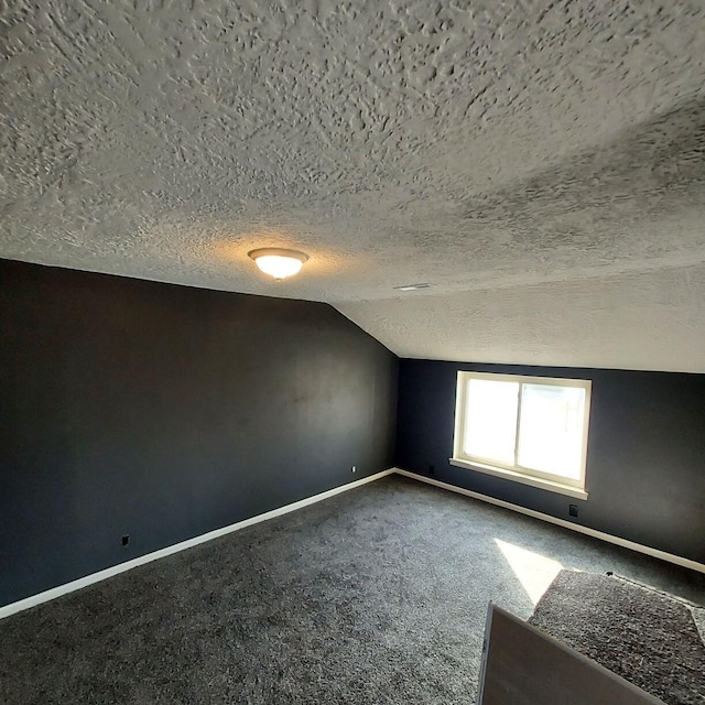 bonus room with a textured ceiling, carpet floors, and vaulted ceiling