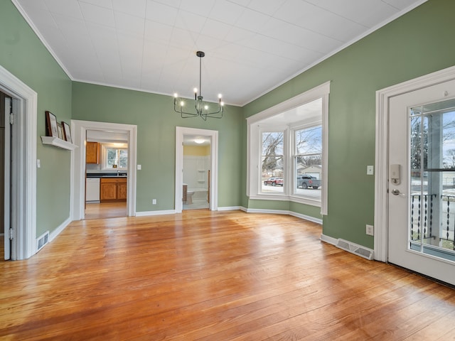 unfurnished dining area with crown molding, plenty of natural light, light hardwood / wood-style floors, and an inviting chandelier