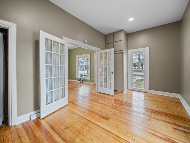 empty room featuring french doors and light hardwood / wood-style floors