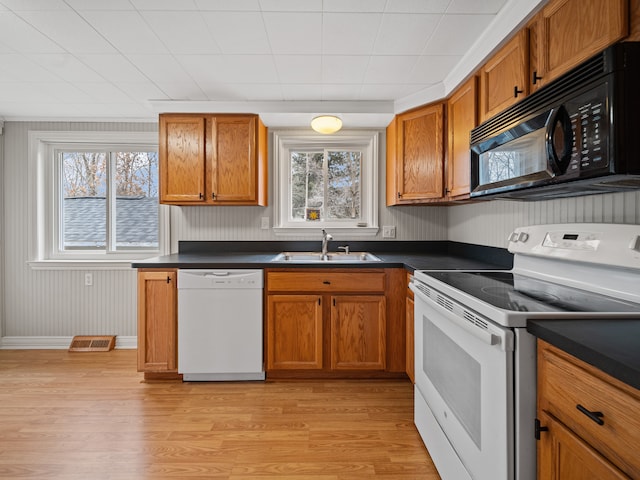 kitchen featuring white appliances, sink, and light hardwood / wood-style flooring