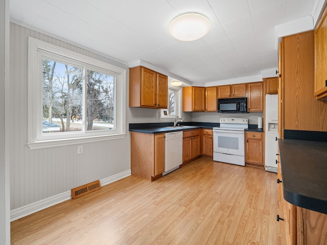 kitchen with light hardwood / wood-style floors, white appliances, and sink