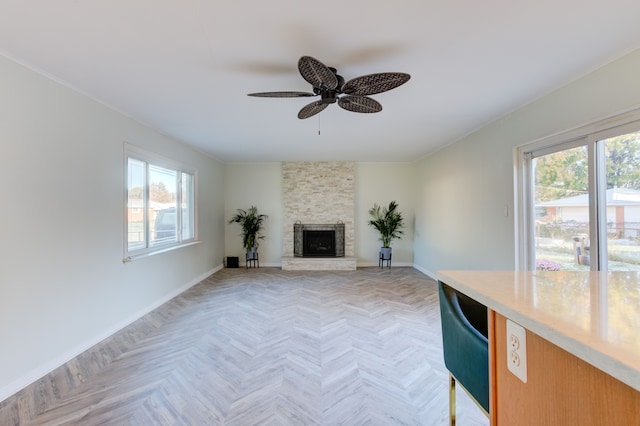 unfurnished living room with ceiling fan, plenty of natural light, a fireplace, and light parquet flooring