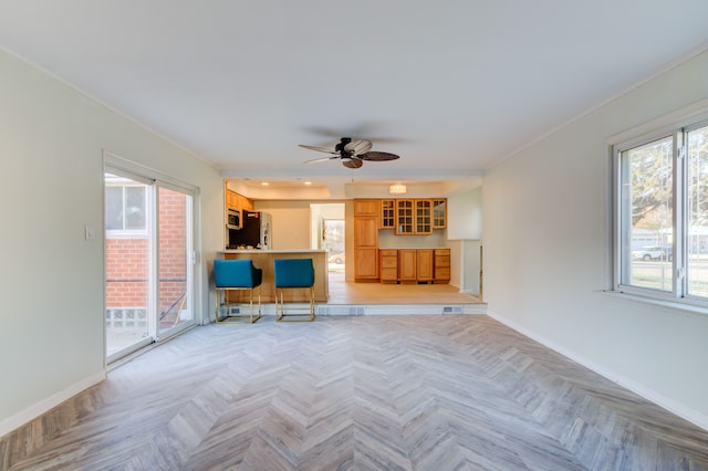 unfurnished living room featuring ceiling fan, crown molding, and light parquet flooring