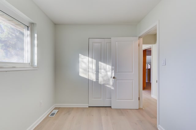 unfurnished bedroom with a closet and light hardwood / wood-style flooring