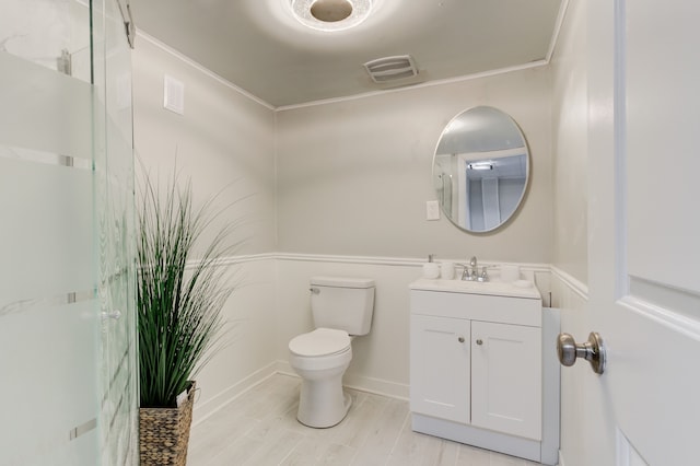 bathroom featuring vanity, toilet, and ornamental molding