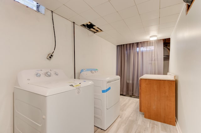 washroom with washer and dryer and light wood-type flooring