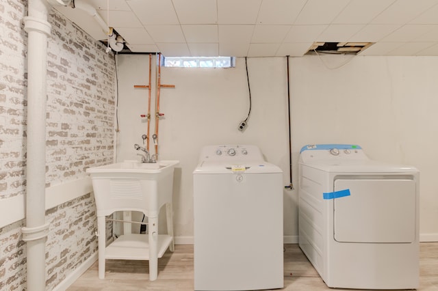 clothes washing area with washer and dryer and light hardwood / wood-style floors