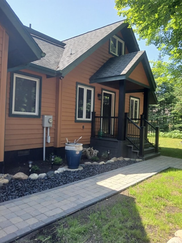 view of front of property with roof with shingles and crawl space