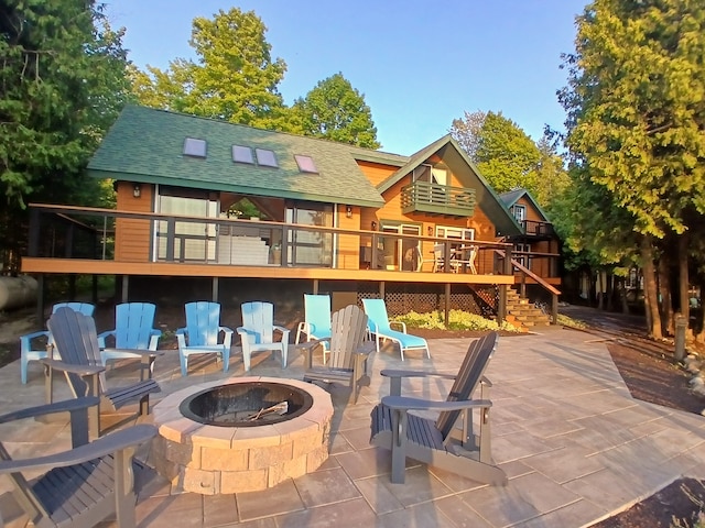 rear view of house featuring a patio area, stairway, an outdoor fire pit, and roof with shingles