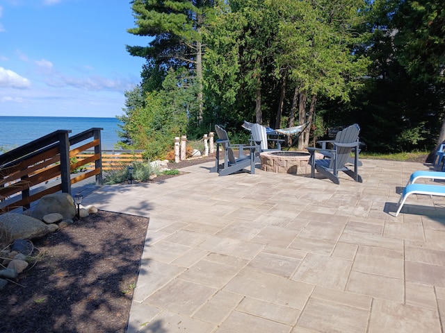 view of patio / terrace with a fire pit and a water view