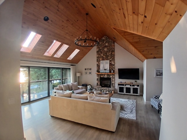 living room with wood finished floors, high vaulted ceiling, a stone fireplace, wooden ceiling, and a chandelier