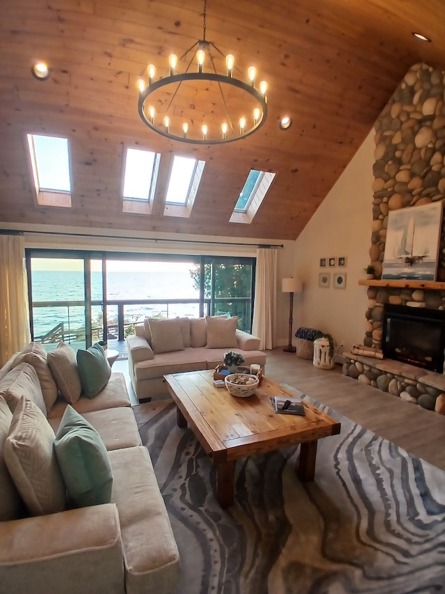 living room with wood finished floors, high vaulted ceiling, a stone fireplace, wood ceiling, and a notable chandelier